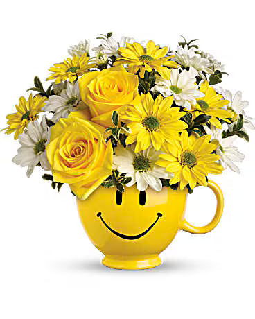 Be Happy Birthday Bouquet – cheerful yellow roses and daisies arranged in a smiley ceramic mug.